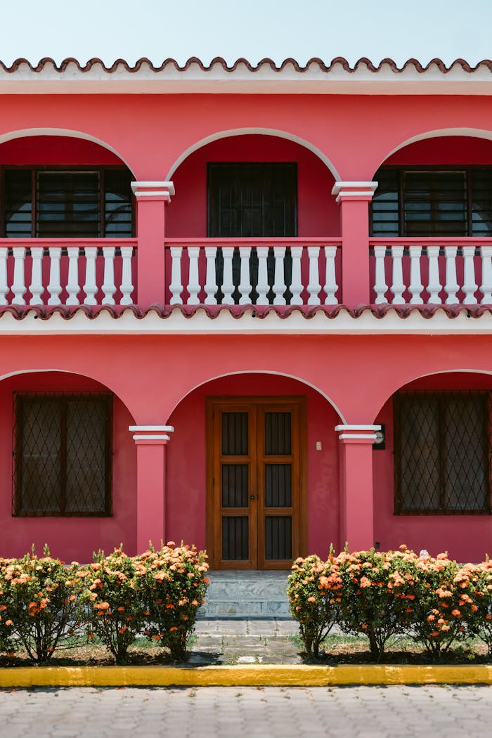 Bright pink colonial building facade in Tlacotalpan, Mexico, showcasing traditional architecture.